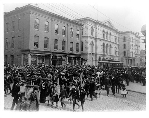 Photo of several hundred African Americans dressed up and parading down a city street for Juneteenth.