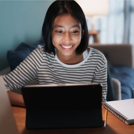 young teen female girl on laptop smiling - used for virtual volunteer - square